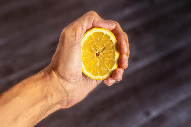 Mano de corte con limón fresco - foto de stock