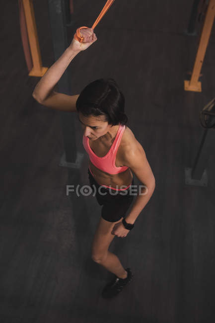 Woman in sportswear doing pull up exercises on horizontal bar in gym — Stock Photo