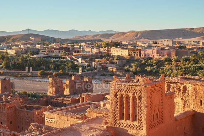 Dall'alto centro storico con costruzioni in pietra vicino a stretto fiume tra deserto e bel cielo con nuvole a Marrakech, Marocco — Foto stock