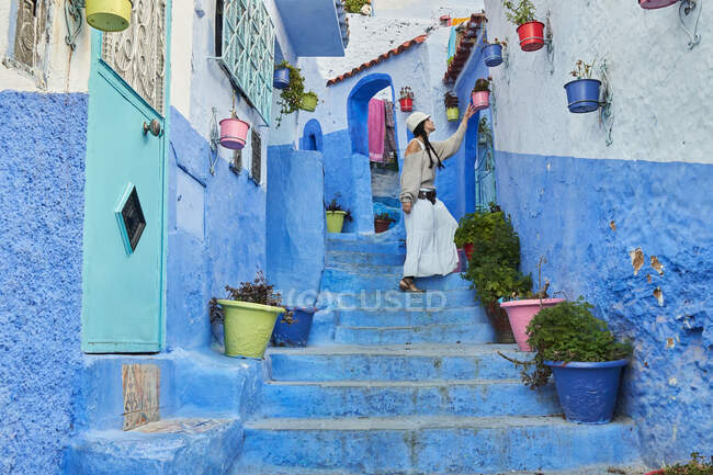Вродлива жінка, що йде між синіми будинками в Марракеші. — стокове фото