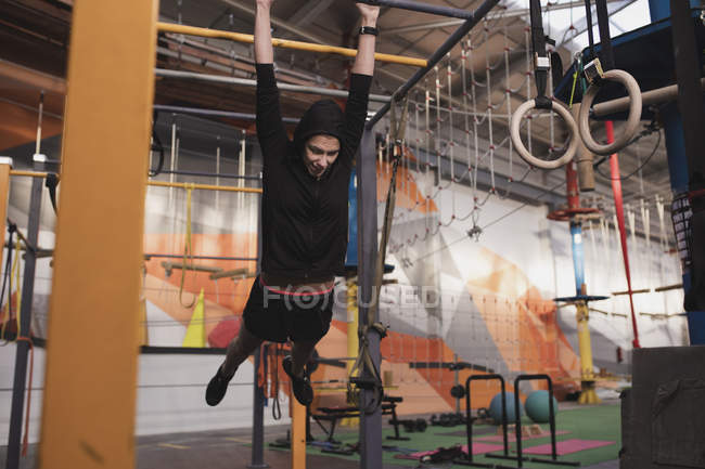Жінка в спортивному одязі робить вправи на горизонтальному барі в спортзалі — стокове фото