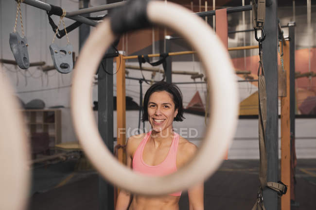 Frau in Sportbekleidung macht Klimmzugübungen am Reck im Fitnessstudio — Stockfoto