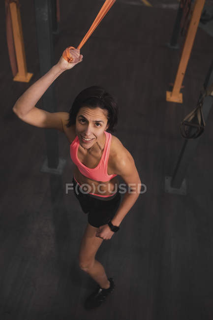 Woman in sportswear doing pull up exercises on horizontal bar in gym — Stock Photo