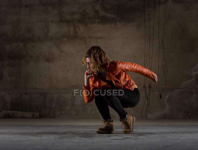 Young woman dancing in grey room — Stock Photo