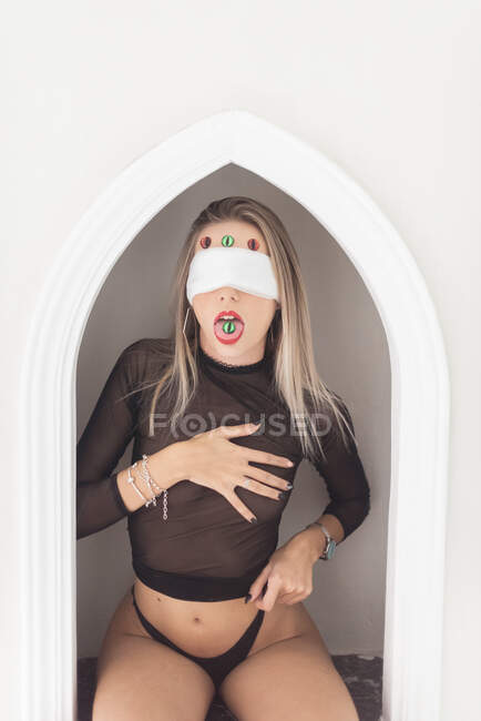 Чувственная женщина с маской и фальшивыми глазами — стоковое фото
