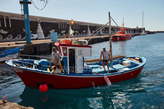 Stadt am Wasser mit blauem Wasser in der Bucht und Segelmotorboot im hellen Sonnenlicht, el hierro — Stockfoto