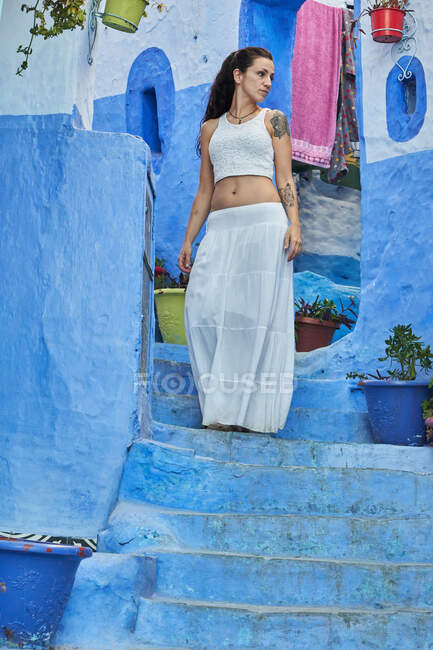 Bela mulher andando entre casas azuis em Marraquexe — Fotografia de Stock