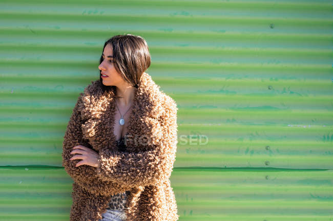 Stilvolle Frau in der Nähe der grünen Mauer — Stockfoto