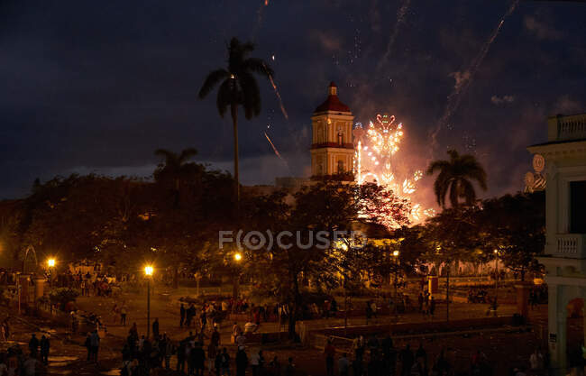 De arriba celebran fiesta en plaza con torre alta por la noche con fuegos artificiales en el cielo en Cuba - foto de stock