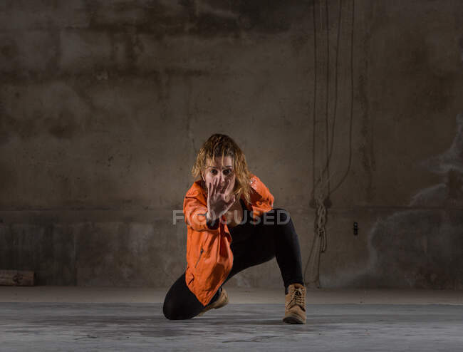 Молода жінка танцює в сірій кімнаті — стокове фото