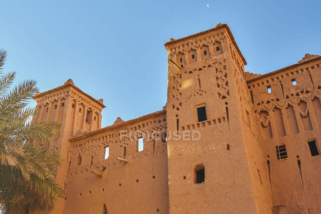 D'en bas façade de construction rocheuse dans la vieille ville et ciel bleu à Marrakech, Maroc — Photo de stock