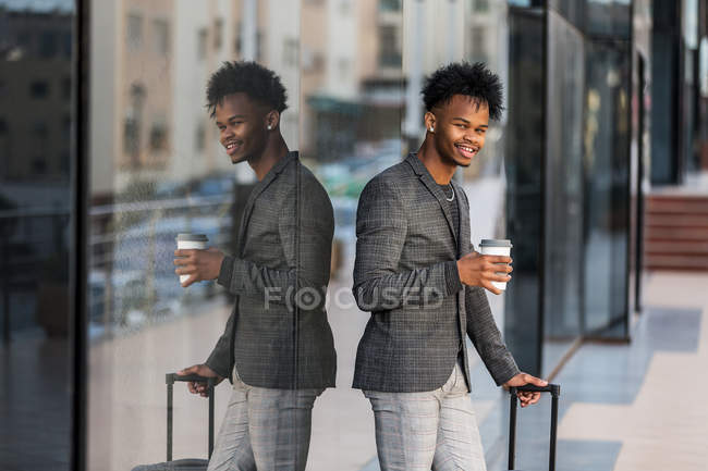 Alegre empresario negro con maleta - foto de stock