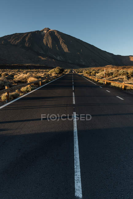 Vista panoramica sulla strada asfaltata in terra asciutta che conduce alle montagne — Foto stock