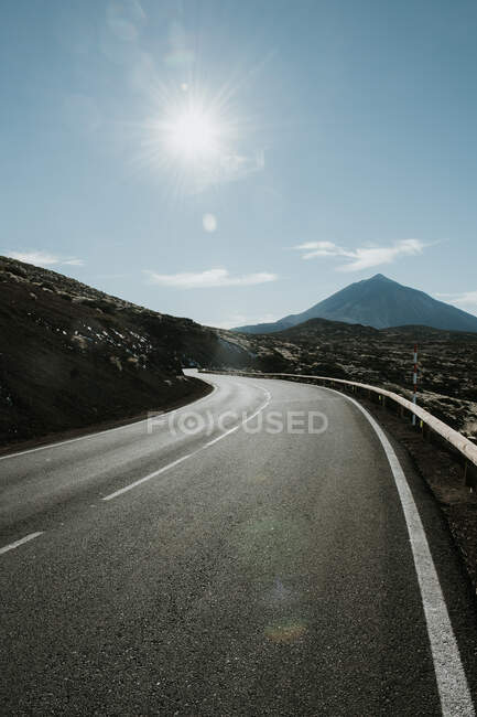 Vue en perspective de la route asphaltée dans la terre ferme menant aux montagnes — Photo de stock