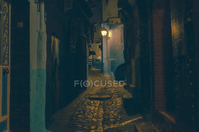 Increíble vista de la calle pobre entre casas antiguas en la noche en Marrakech, Marruecos - foto de stock