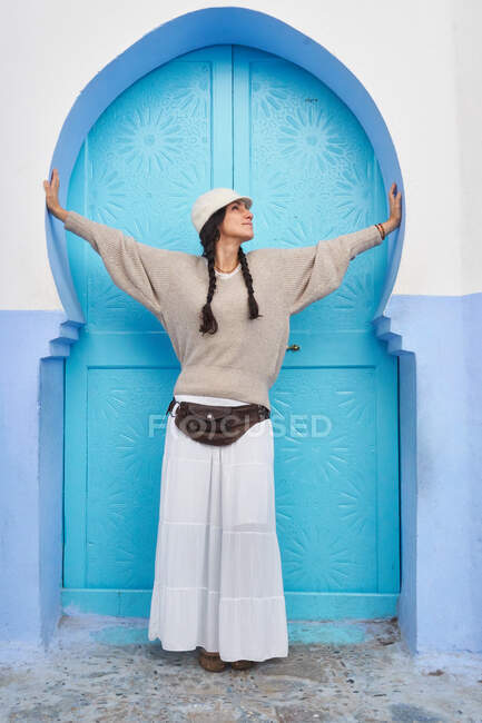 Beautiful woman walking between blue houses in Marrakesh — Stock Photo