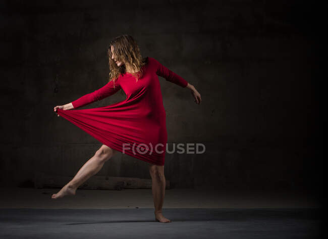 Young woman dancing in darkness — Stock Photo