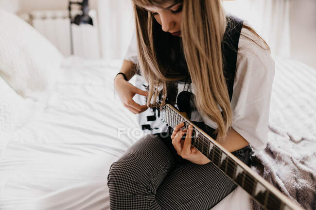 Jeune femme brune jouant de la guitare — Photo de stock