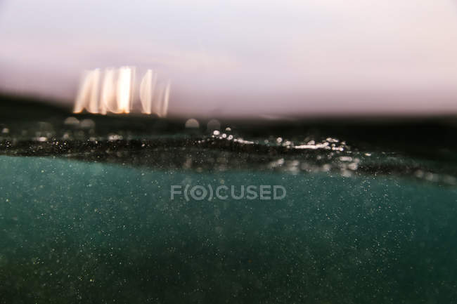 Знизу з видом бризок у блакитній воді океану — стокове фото