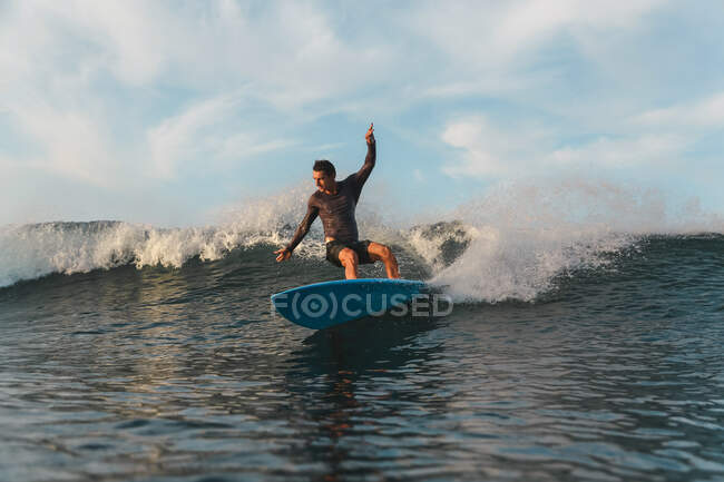 Чоловічий серфінг між морською водою і брижами на Балі (Індонезія). — стокове фото