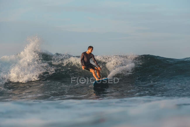 Surf masculin entre les vagues de l'eau de mer avec des éclaboussures à Bali, Indonésie — Photo de stock
