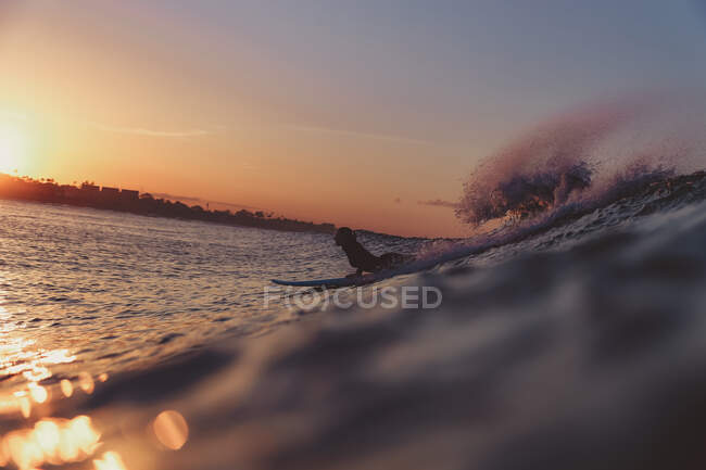 Frau surft zwischen wogendem Meereswasser mit Spritzern in Bali, Indonesien — Stockfoto