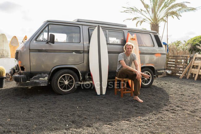 Homem de pé perto de pranchas de surf e van — Fotografia de Stock