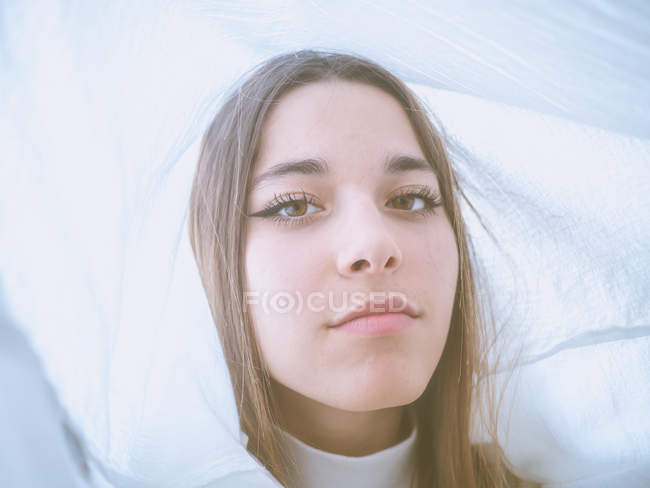 Proud teen white wear looking at camera between light curtains — Stock Photo