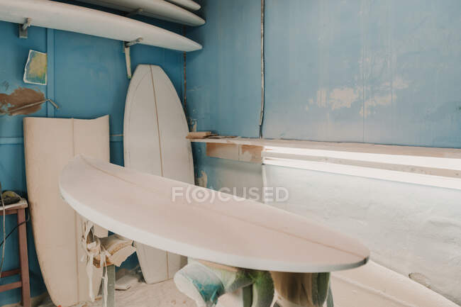 Taller con tablas de surf cerca de diferentes herramientas - foto de stock