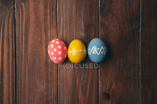 Красочные окрашенные пасхальные яйца на деревянном столе — стоковое фото