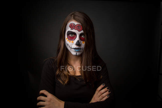 Mujer joven con pintura facial espeluznante - foto de stock
