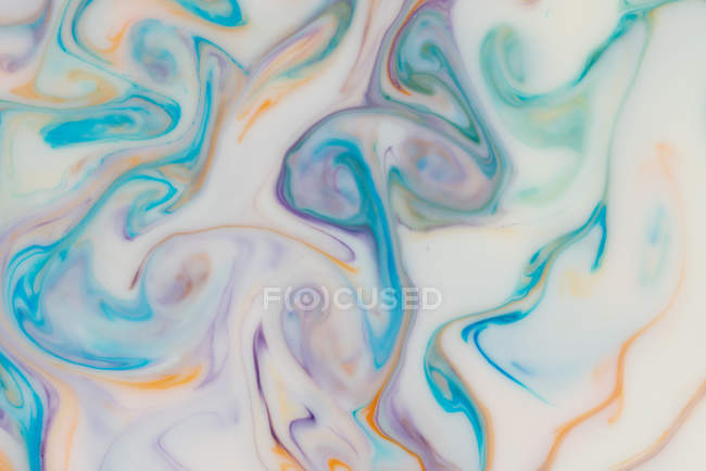 Abstract flow of colorful liquid paints in mix — Stock Photo