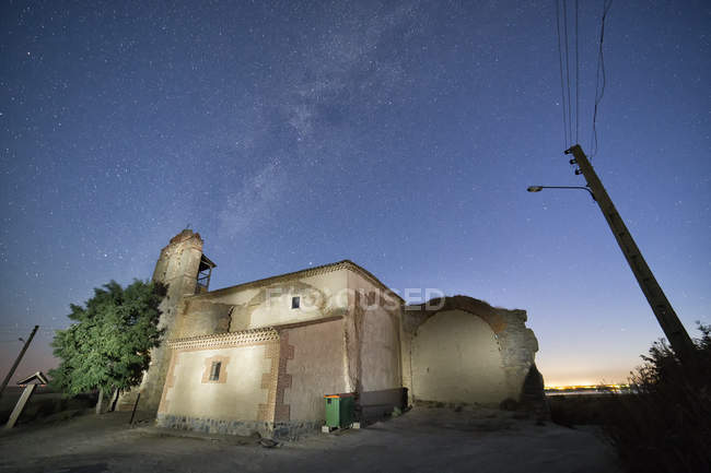 Зовнішня кам'яна церква в сільській місцевості під величним небом у вигляді зірок уночі — стокове фото