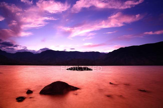 Majestic landscape of mountains and lake in long exposure with bright pink color, Spain — Stock Photo