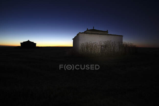 Exterior de antigua casa de piedra en paisaje rural bajo majestuoso cielo en estrellas, España - foto de stock