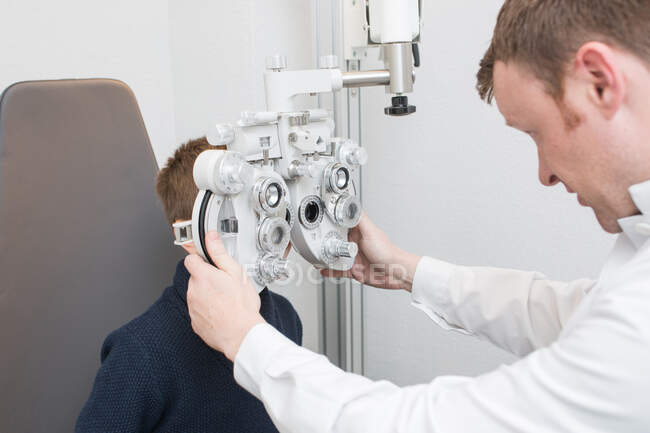 Optiker testet Jungenaugen mit Optometriegeräten — Stockfoto