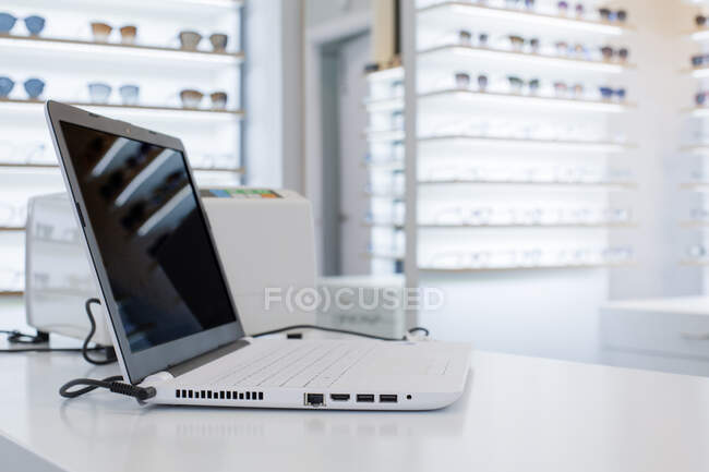 Computer portatile su un tavolo in un negozio di occhiali — Foto stock