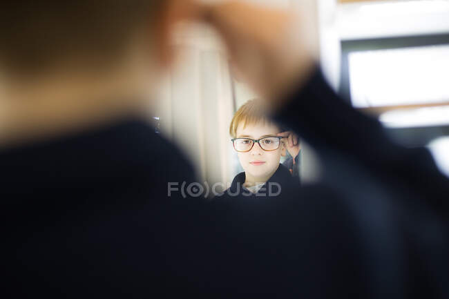 Mignon jeune garçon essayer des lunettes dans un magasin de lunettes — Photo de stock