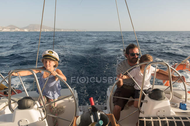 Father and son floating on expensive boat on sea and blue sky in sunny day — Stock Photo