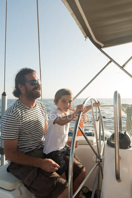 Father and son floating on expensive boat on sea and blue sky in sunny day — Stock Photo