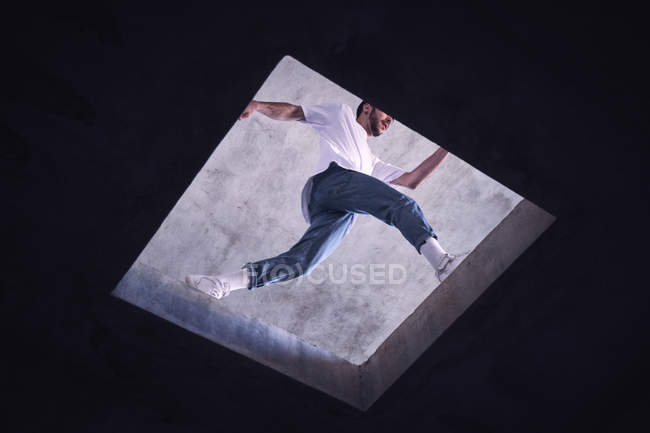 Young dancer jumping on roof, low angle view — Stock Photo