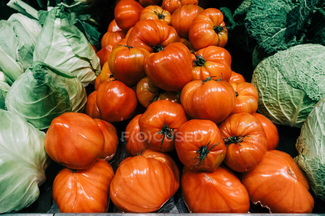 Close up pile of fresh ripe tasty red tomatoes and cabbage — Stock Photo