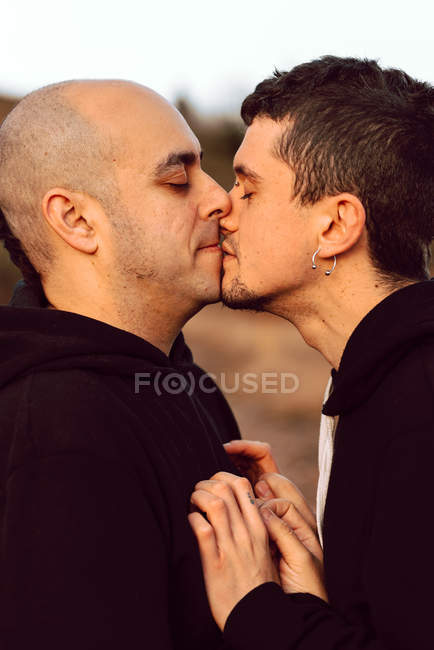 Closeup of homosexual couple kissing on path in nature — Stock Photo