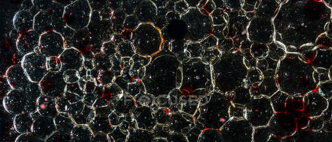 Крупный план многих пузырьков в темном масле — стоковое фото