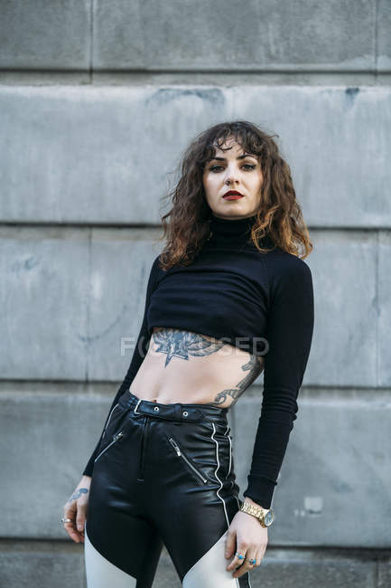 Young tattooed woman posing sensual in the street — Stock Photo