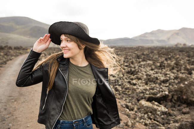 Hübsche Frau schaut vor steinigem Gelände weg — Stockfoto