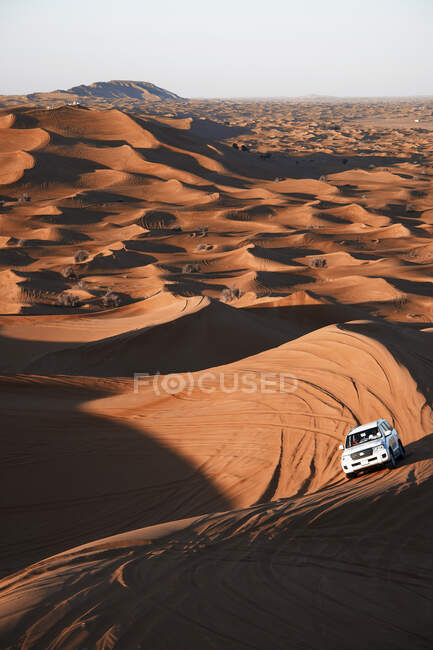 Safari on off-roader driving between sand dunes in sunny day in Dubai, United Arab Emirates — Stock Photo