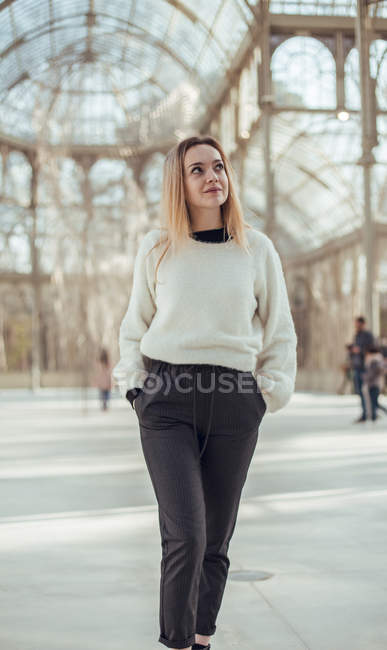 Stylish smiling young woman walking in Crystal Palace in Madrid, Spain — Stock Photo