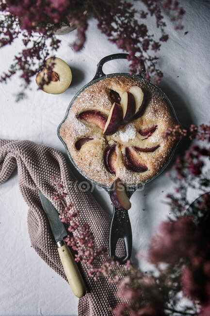 Du dessus gâteau de prune de sucre cuit frais dans une poêle sur une table — Photo de stock
