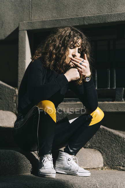 Young beautiful woman smoking cigarette in the street — Stock Photo